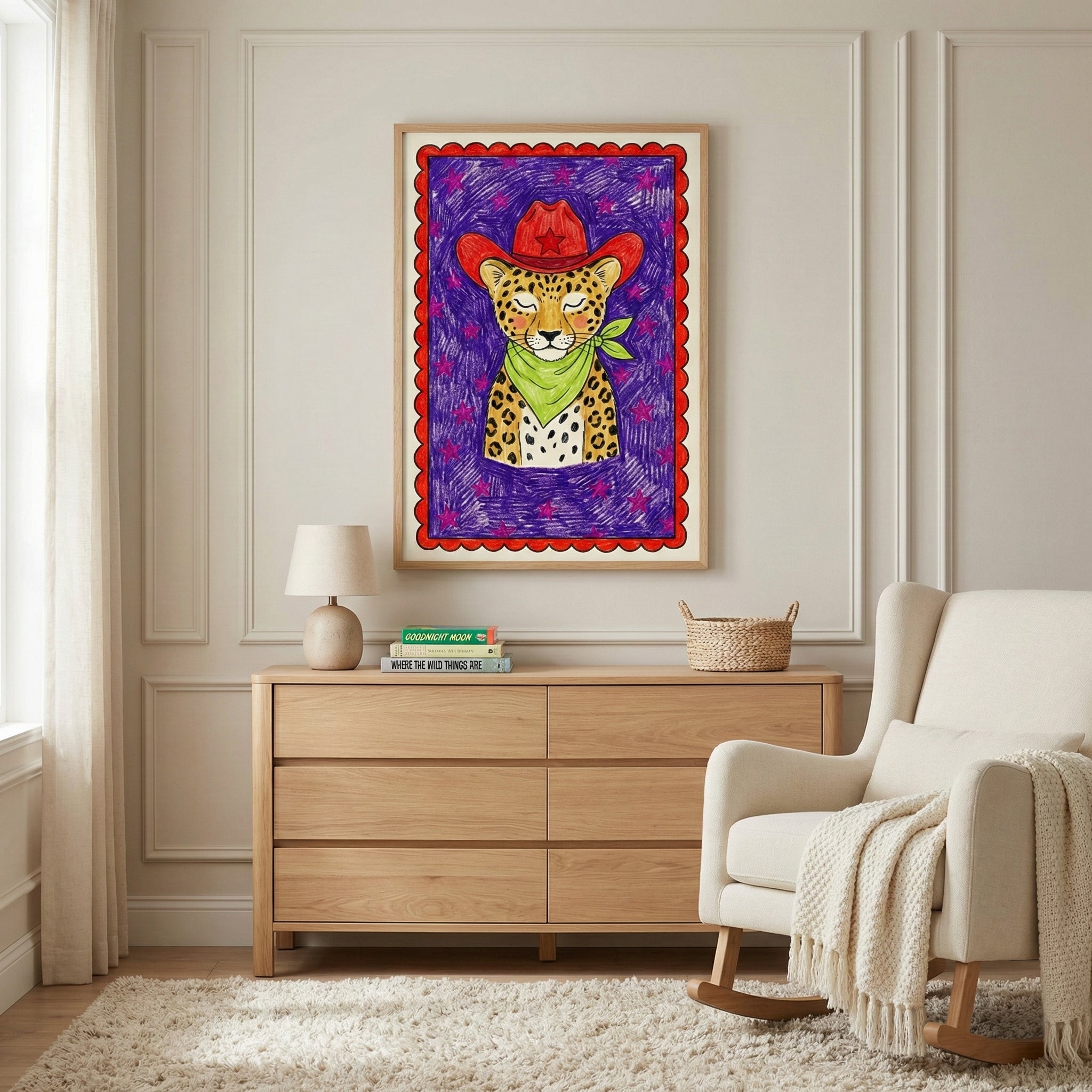 Playful leopard cowboy artwork featuring a red hat and green bandana hangs above a light wood dresser in a cozy, neutral-toned nursery. The bold illustration contrasts with the soft, minimalist decor of the room.