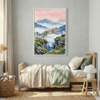 A large, framed artwork of a snow leopard jumping between two rocky cliffs hangs on a gray wall above a child’s bed. The illustration is in a watercolor style, featuring misty blue mountains under a soft pink sunset sky with birds in flight. The wooden bed has neutral-toned bedding. To the side, a cloud-shaped lamp sits on a small stool next to a stack of books. A woven basket filled with soft toys is on the natural fiber rug below, creating a serene and cozy atmosphere.
