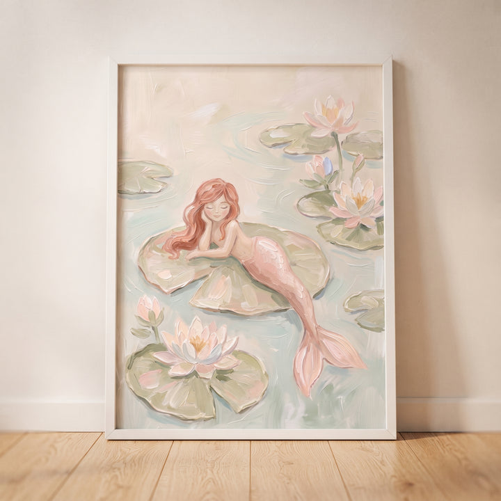 Lily pad pink mermaid wall art of a red-haired mermaid resting on a large leaf among soft pink water lilies.