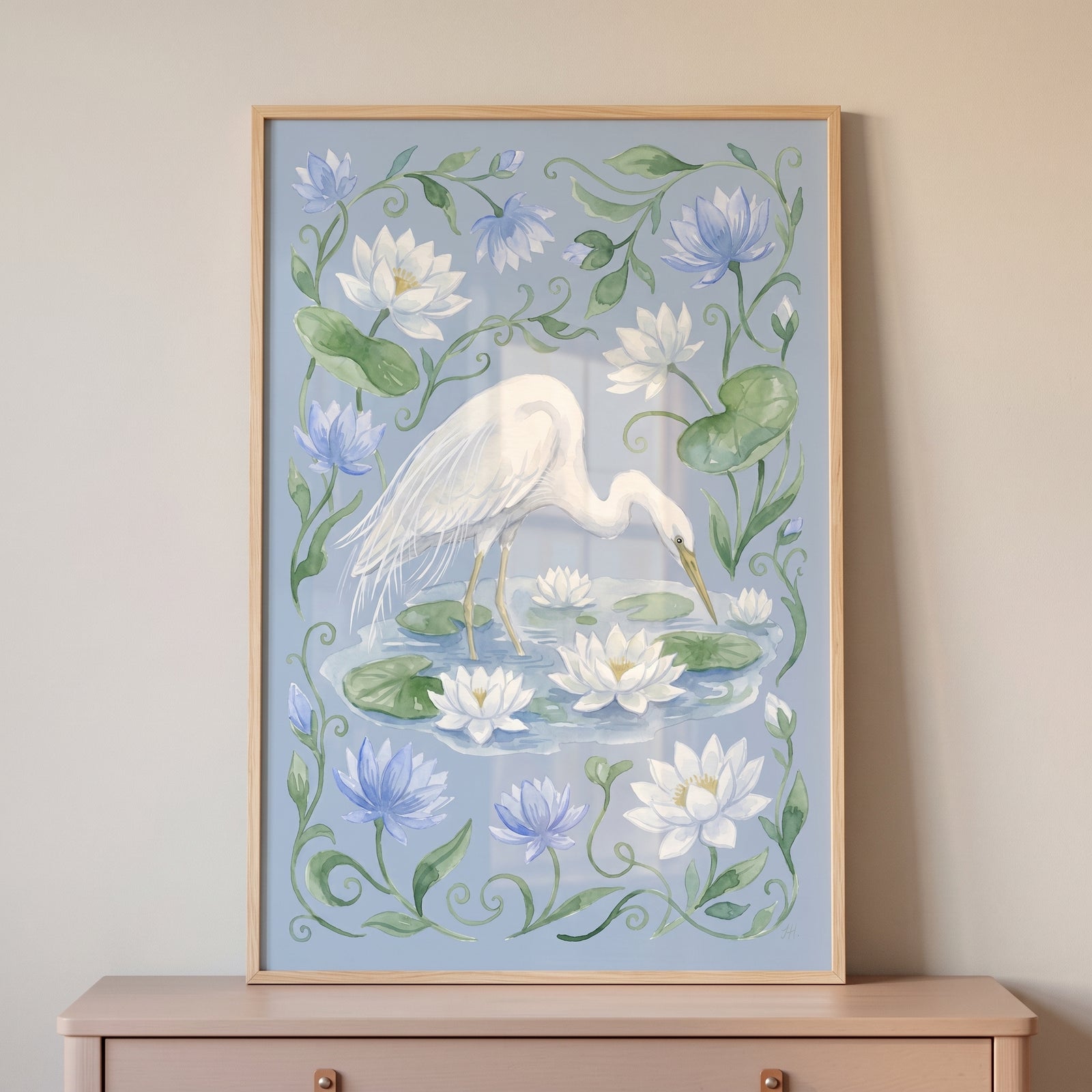 Lily pad white egret bird wall art in a wooden frame featuring a white bird standing among blue and white flowers.