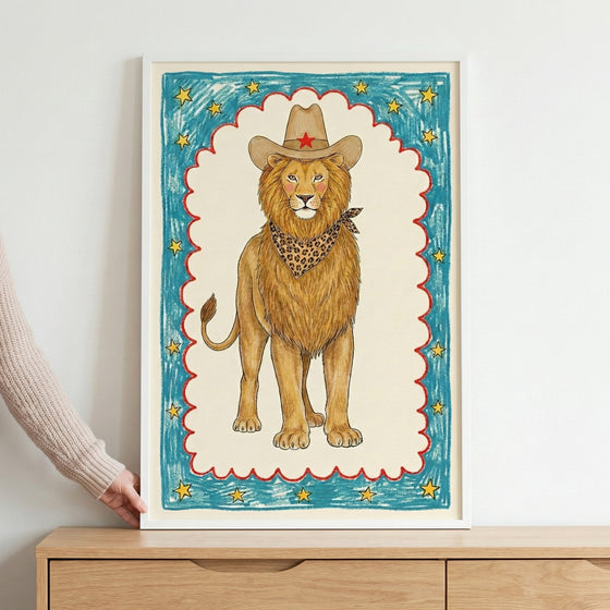 A whimsical, child-like illustration of a majestic lion wearing a brown cowboy hat with a red star and a leopard-print bandana, centered within a scalloped red border on a textured blue background filled with yellow stars.