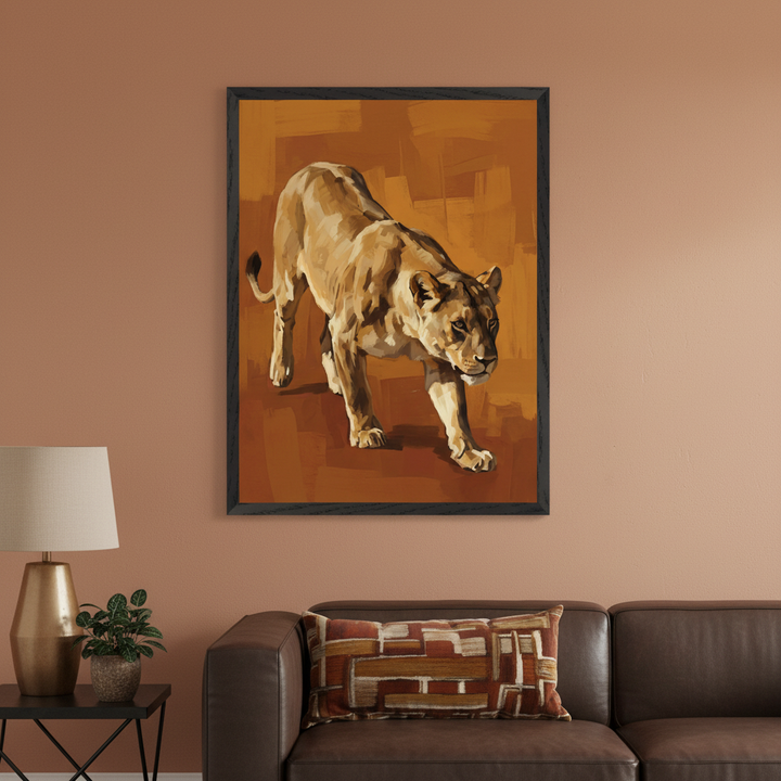 Living room with a brown leather sofa. A large framed painting of a walking lioness, in a painterly style with warm orange and brown tones, hangs on the wall above the sofa. A side table with a lamp and plant is on the left.