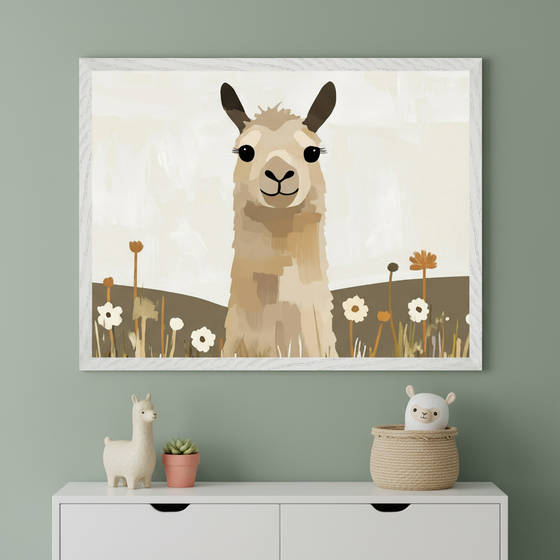 Framed illustration of a smiling llama standing in a whimsical field of neutral-toned flowers with soft hills in the background. Below the artwork, a white dresser displays a ceramic llama, a small potted succulent, and a plush llama toy peeking out of a woven basket, all set against a muted green wall.