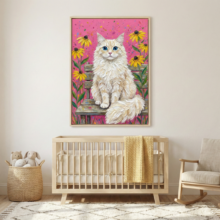 An impasto-style artwork featuring a fluffy, cream-colored cat with striking blue eyes sitting on a weathered wooden bench. Vibrant yellow flowers with dark centers frame the feline against a bright pink background with colorful speckles. This textured canvas hangs in a light wood frame on a neutral nursery wall. Below it is a light-toned wooden crib with a yellow knit blanket. A woven basket of plush toys and a simple rocking chair complete the warm, whimsical room.