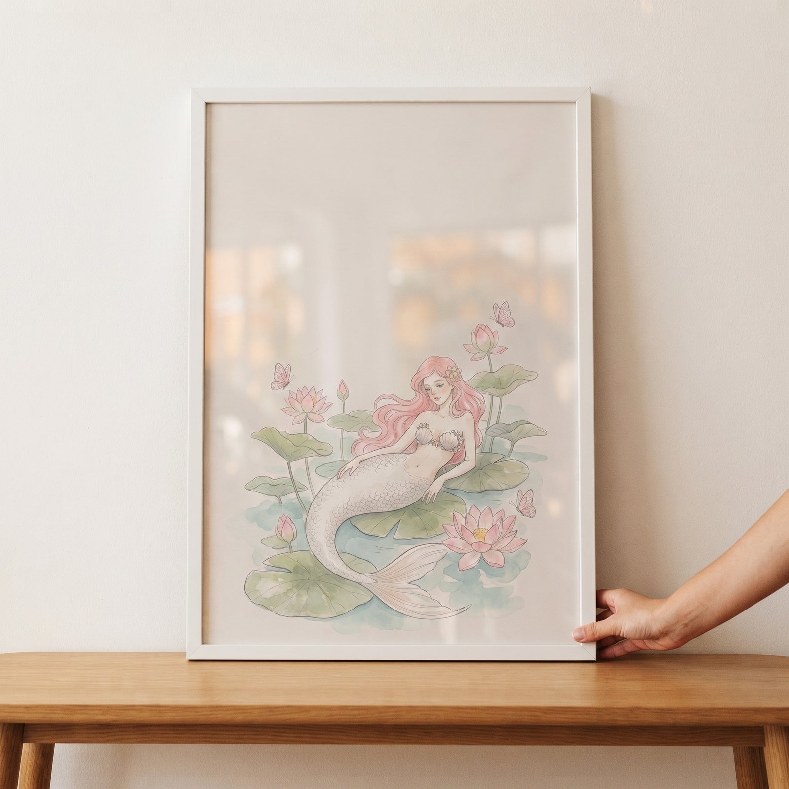 Framed long pink hair mermaid wall art depicts a mermaid among pink lotus flowers and green lily pads on a wooden table.