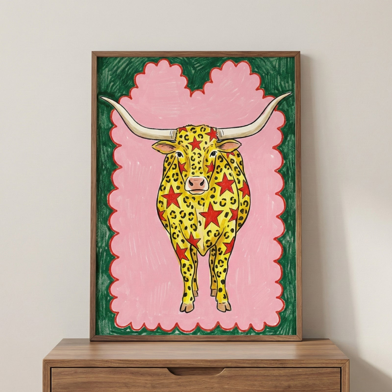 Colorful illustration of a longhorn cow with yellow and red star-leopard spots, set against a pink background with a green and red border.