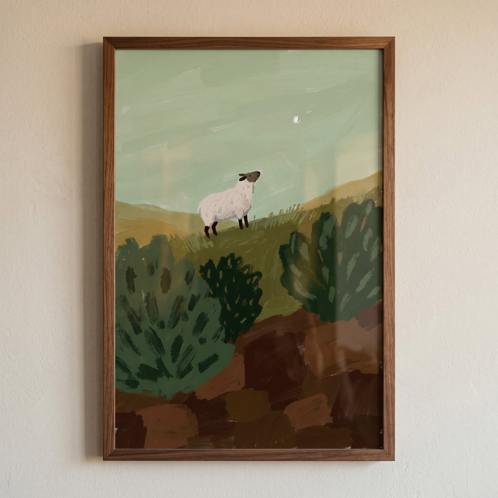 Framed looking up woolly sheep wall art shows a sheep on a green hill gazing at the moon against a pale sky.
