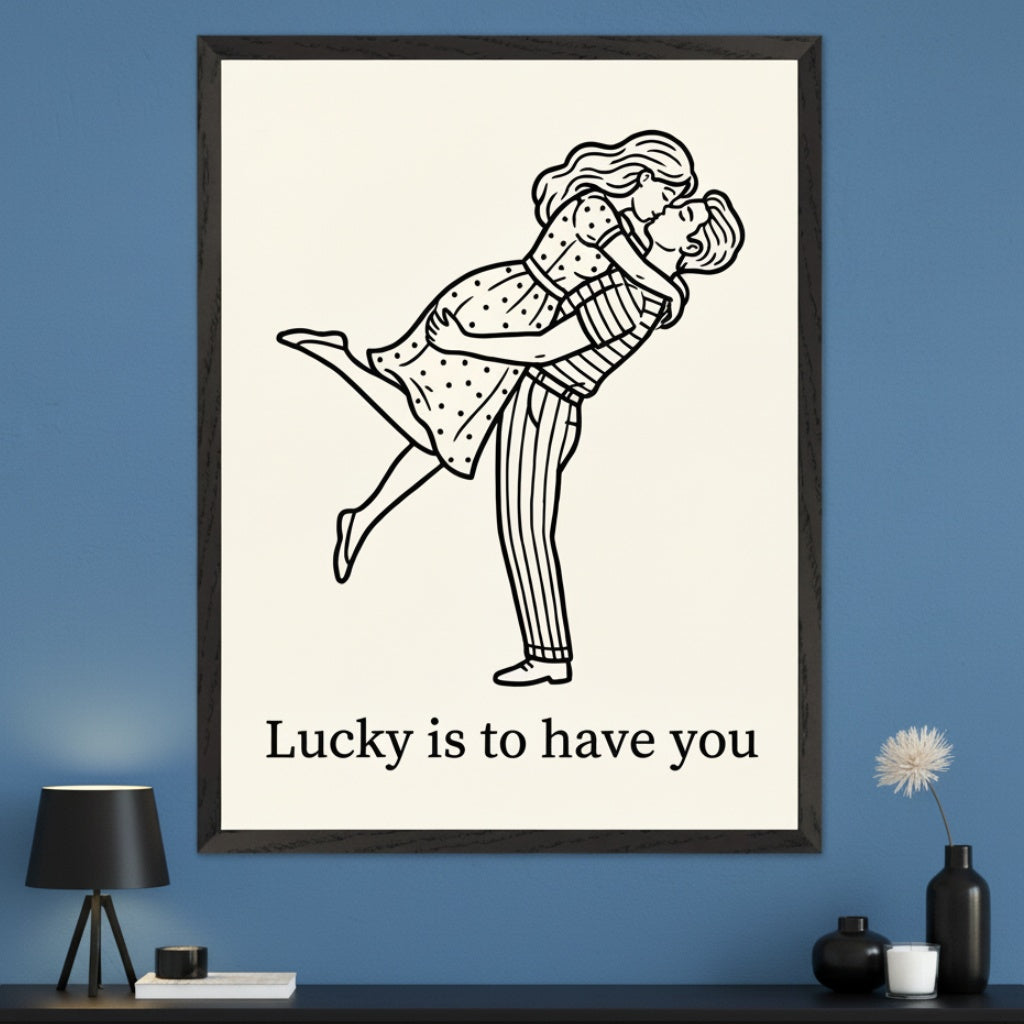 Modern living room with a dark console table. A large framed print hangs centered above the table on a blue wall. It features a black and white line drawing of a man embracing and kissing a woman, with 'Lucky is to have you' written below.