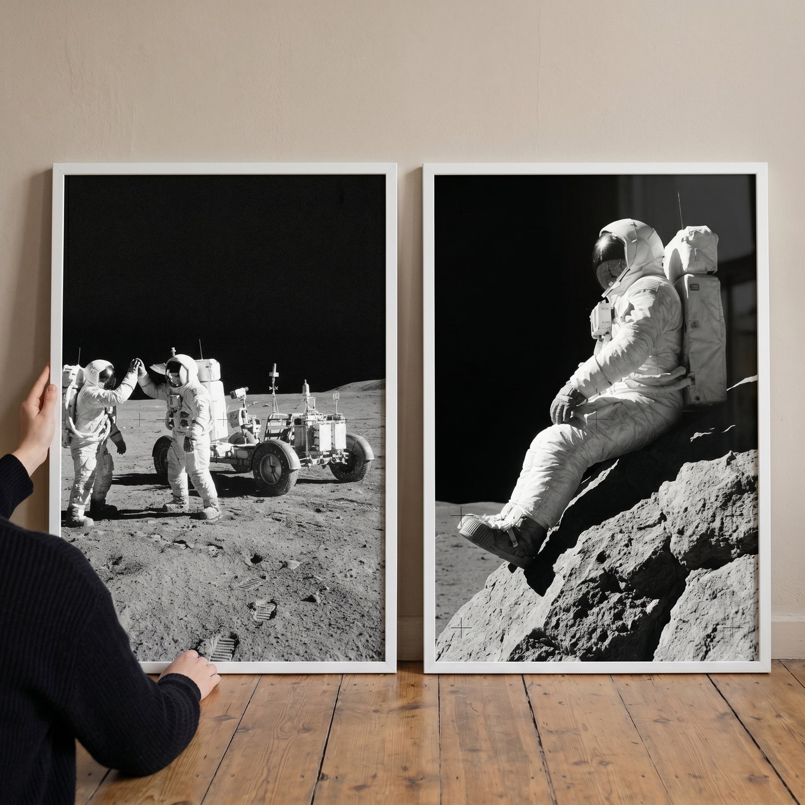 Lunar surface vintage astronaut artwork set of 2 in white frames showing moon explorers high-fiving and sitting on rocks.
