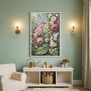 A serene child's nursery features a soft sage green wall adorned with a large, vertical framed illustration of a whimsical garden. The artwork depicts two delicate, winged fairies among a lush arrangement of oversized pink and white roses; one fairy pours liquid from a small pitcher into a teacup held by the other.