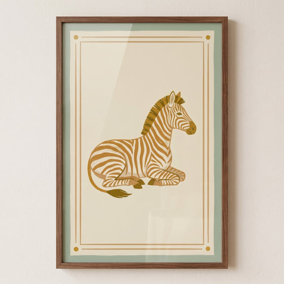 Lying brown zebra wall art in a wood frame featuring a stylized zebra on a cream background with a green border.