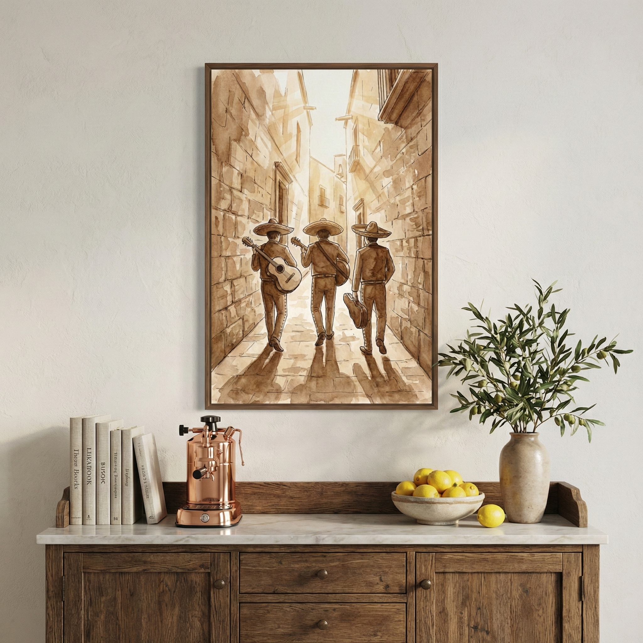 A framed sepia-toned artwork hangs on a light wall over a wooden sideboard. The illustration shows three musicians wearing sombreros and traditional clothing, walking down a sunlit, narrow stone alley. Two carry guitars, while the third has an instrument case. On the rustic cabinet below are several books, a copper-colored coffee machine, a bowl of yellow lemons, and a vase with green foliage. The scene has a warm, vintage feel, characterized by soft earth tones and a curated look.