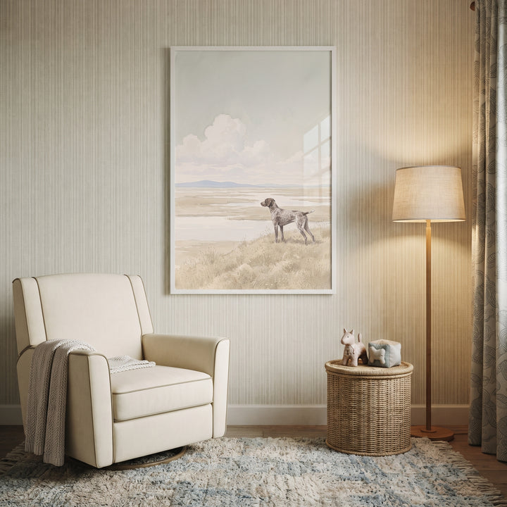 Marsh landscape shorthaired pointer dog wall art hangs above a cream armchair and woven side table in a neutral room.