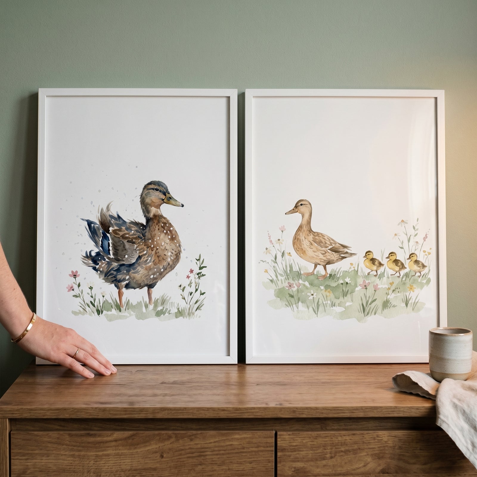 Meadow brown duck wall art set of 2 watercolor illustrations of ducks and ducklings displayed on a wooden dresser.
