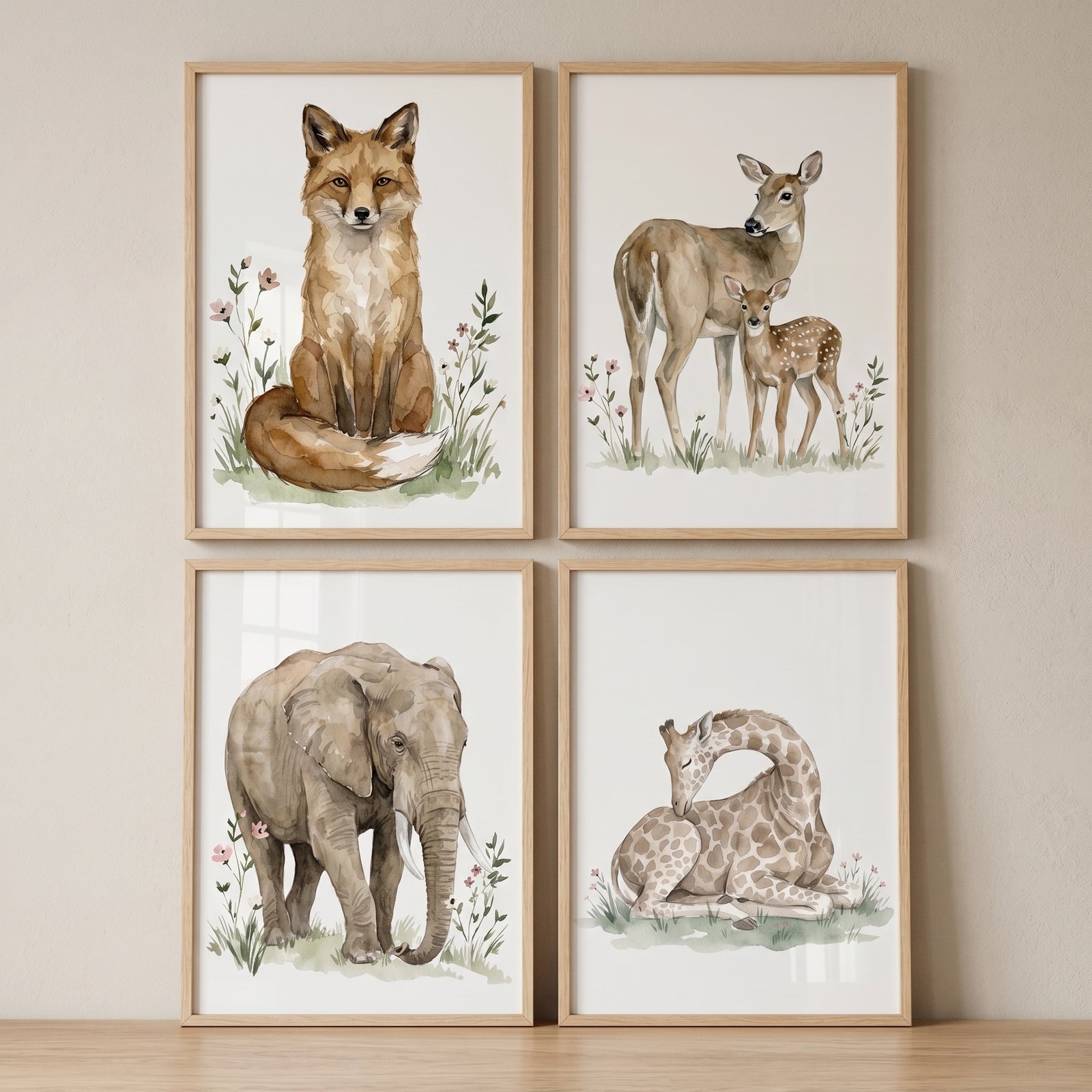 Watercolor fox, deer, elephant, and giraffe meadow wildflower nature animal wall art set of 4 in light wood frames.