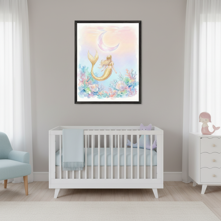 Modern nursery with a white crib, light blue armchair, and white dresser. A black-framed watercolor print of a golden-tailed blonde mermaid, coral, shells, and a crescent moon hangs centered above the crib. A pink mermaid figurine is on the dresser.