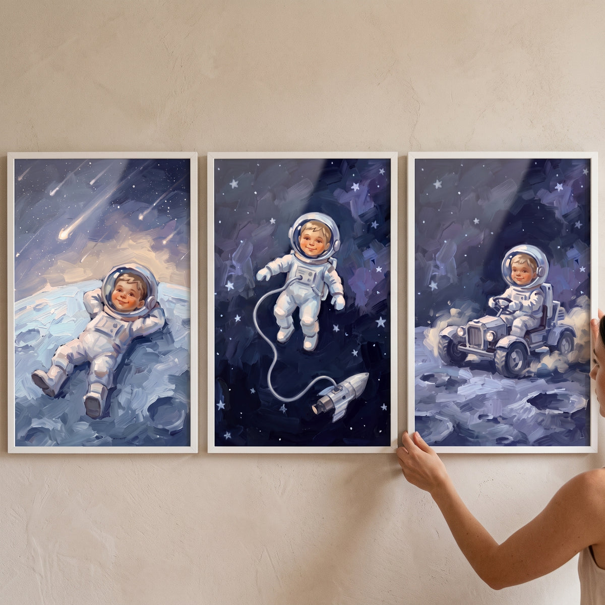 Midnight cosmic baby astronaut wall art set of 3 shows a child lying on the moon, floating in space, and driving a rover.