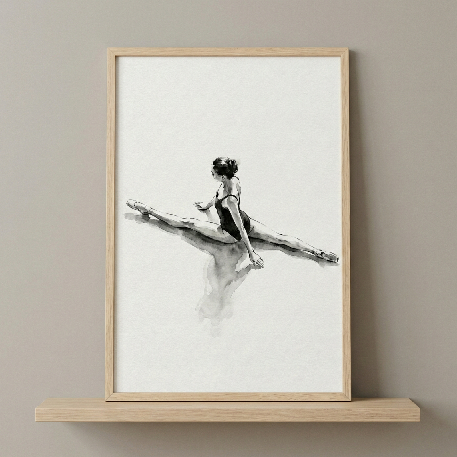 A vertical rectangular frame with a light wood finish holds a black and white monochromatic artwork. The piece features an expressive ink wash or charcoal sketch of a ballet dancer on a stark white background. Shown from a rear perspective, the dancer is wearing a dark leotard and performing a wide side split. Her body is angled slightly, with one hand resting on the ground for balance. A soft, blurred reflection of her form appears on the polished surface beneath her. 