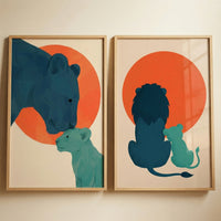 Two minimalist graphic illustrations are displayed side-by-side in light wood frames against a neutral wall. Both pieces feature stylised wild felines in a modern, flat aesthetic.
