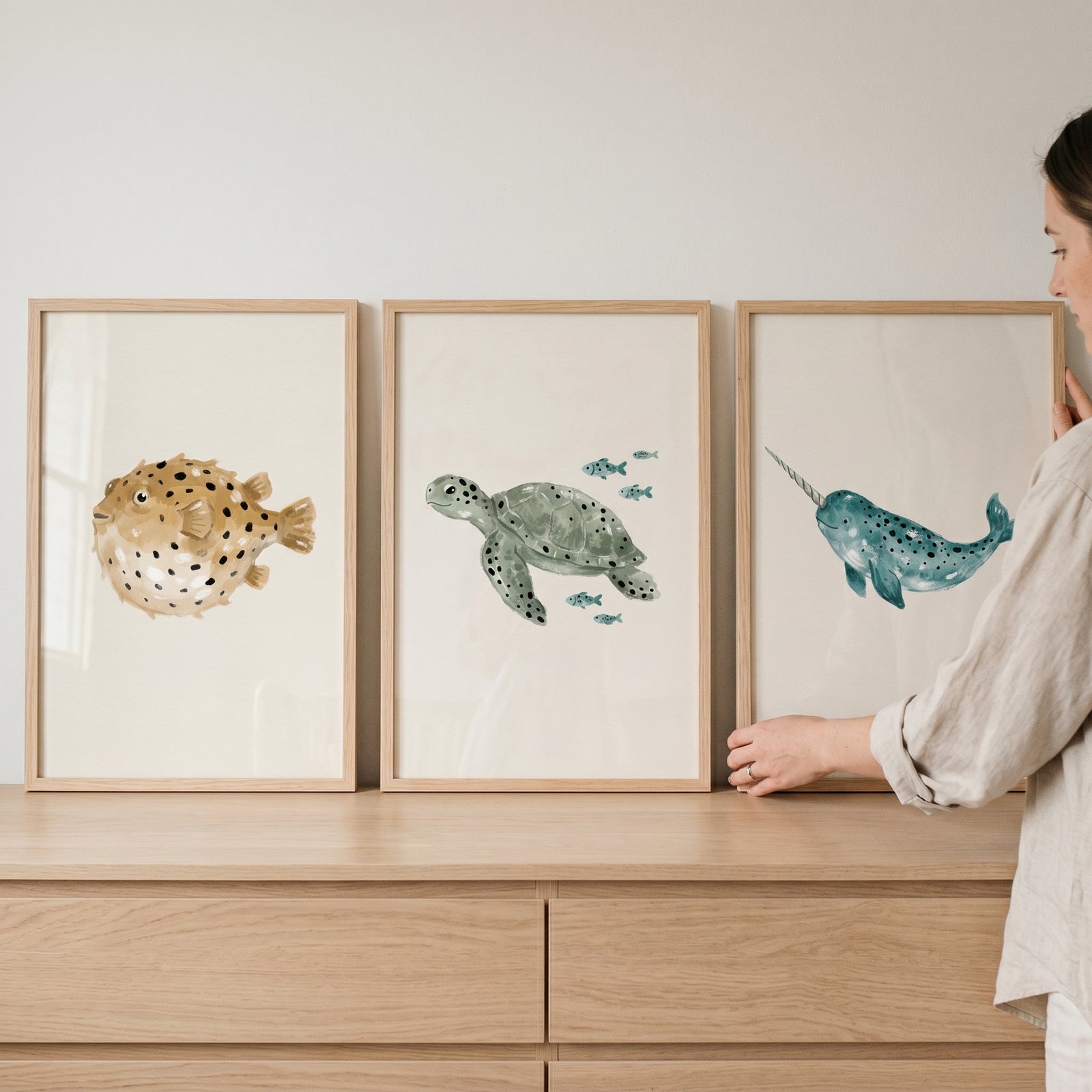 Minimalist spotted ocean animals wall art set of 3 featuring a pufferfish, sea turtle, and narwhal in wooden frames.