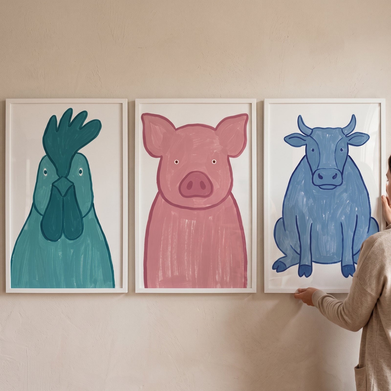 Minimalist whimsical farm animals artwork set of 3 features a teal rooster, pink pig, and blue cow in white frames.