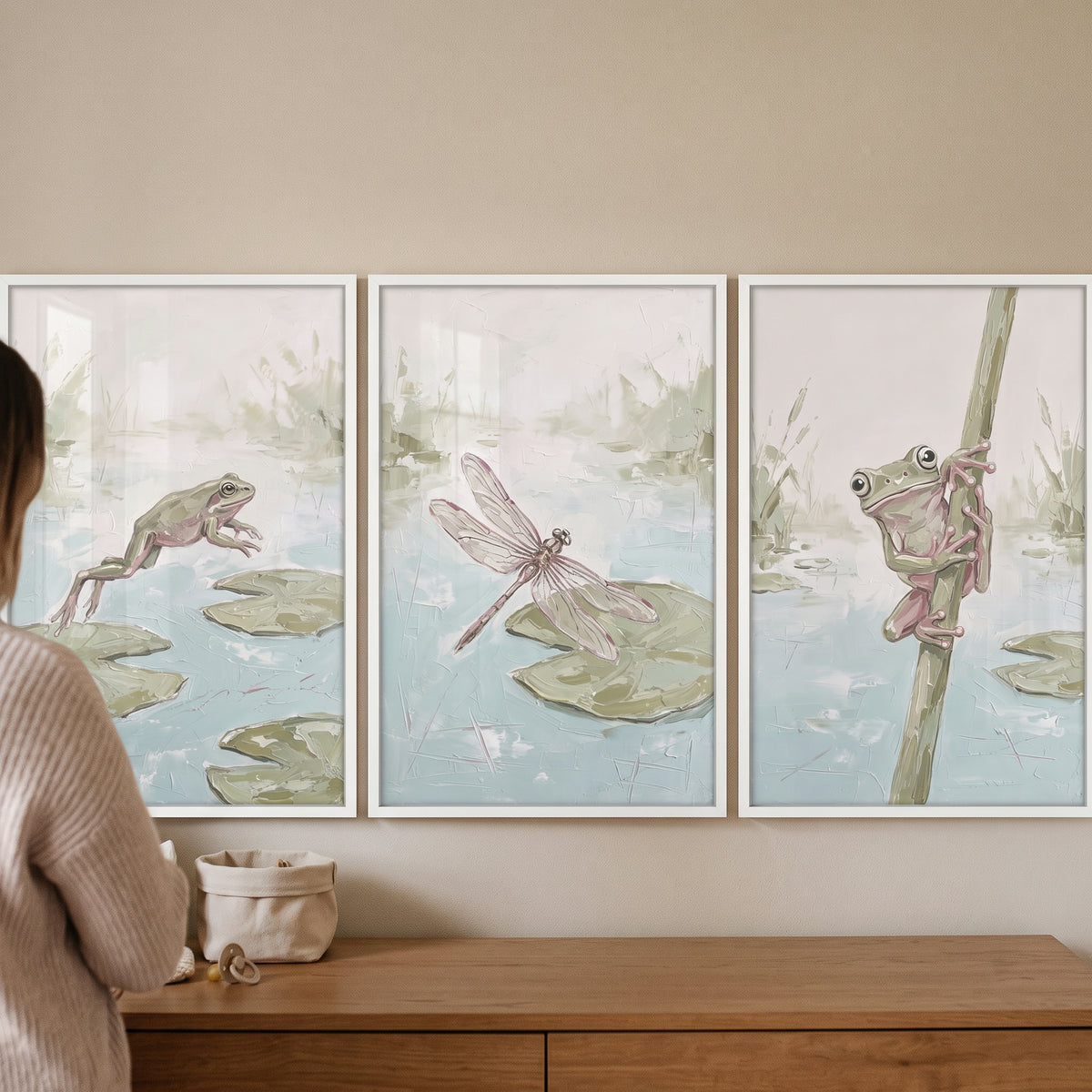 Misty sage pond animals wall art set of 3 featuring frogs and a dragonfly in a soft nature scene above a wood dresser.