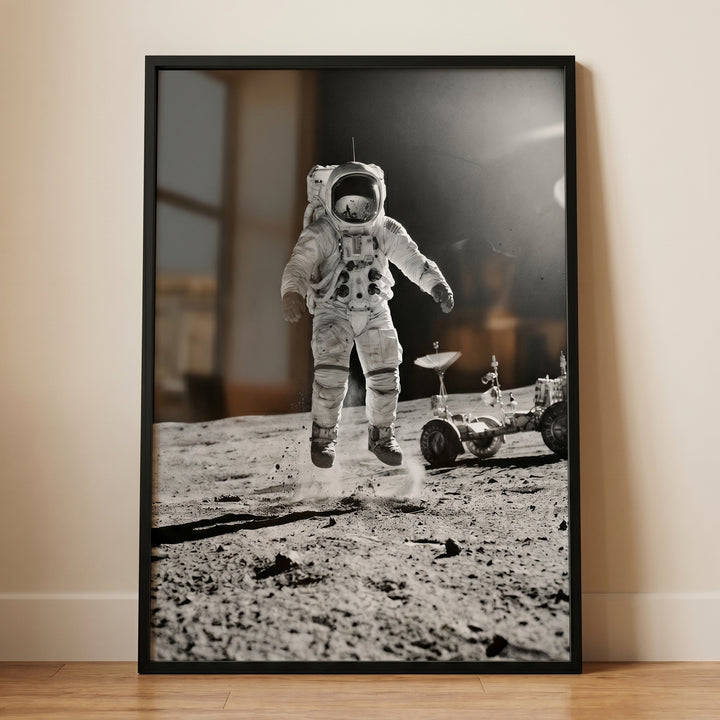 Monochrome moon jumping astronaut wall art shows a space explorer leaping above the cratered surface next to a rover.