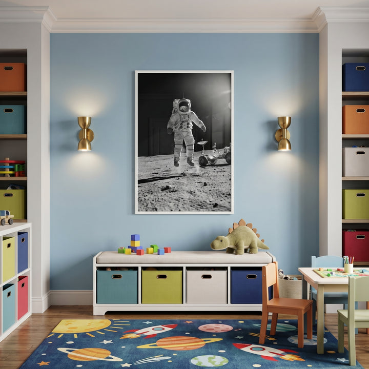 Monochrome moon jumping astronaut wall art in a blue room with gold sconces, a storage bench, and a space-themed rug.