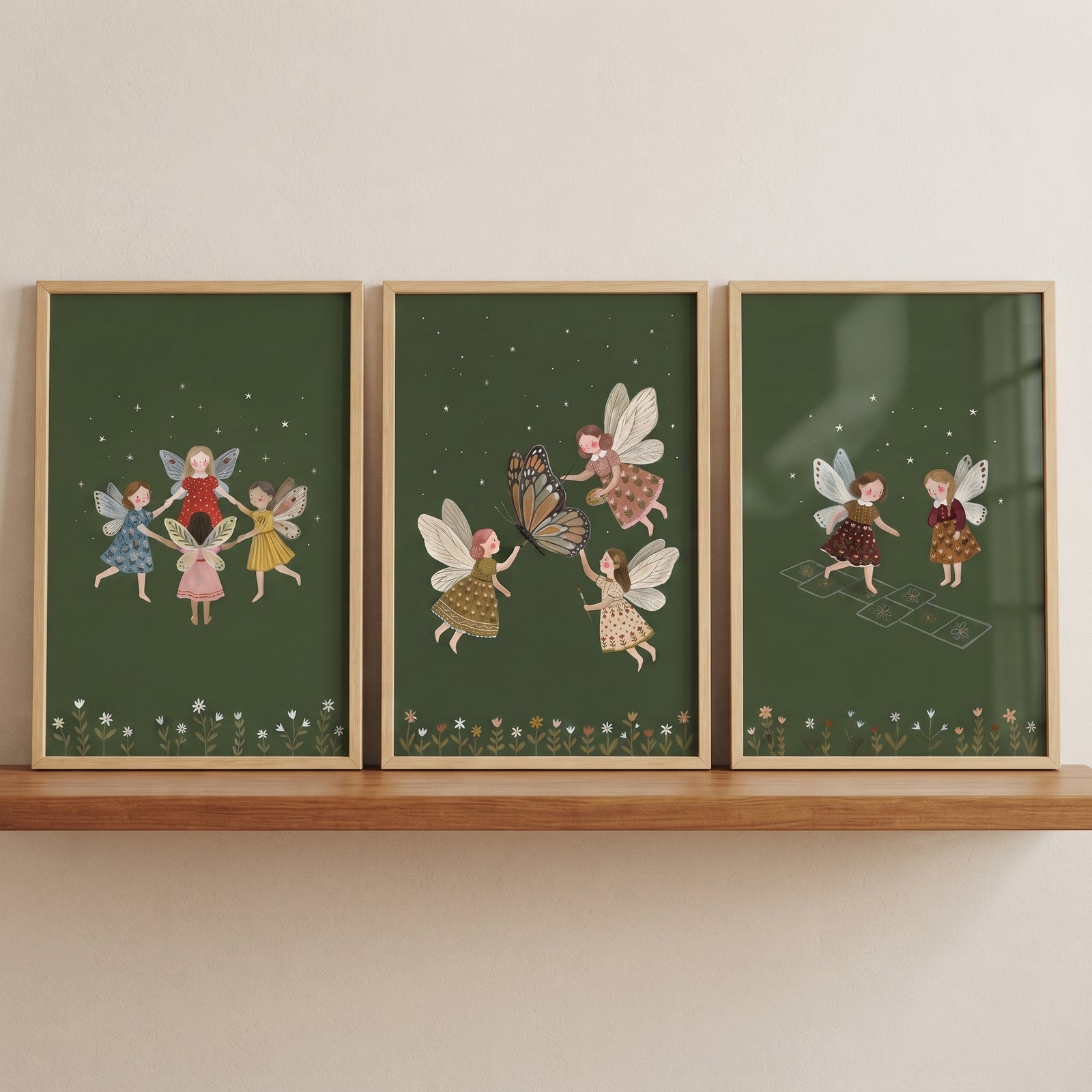 Moody forest floor fairies wall art set of 3 depicts fairies playing games on dark green backgrounds on a wooden shelf.