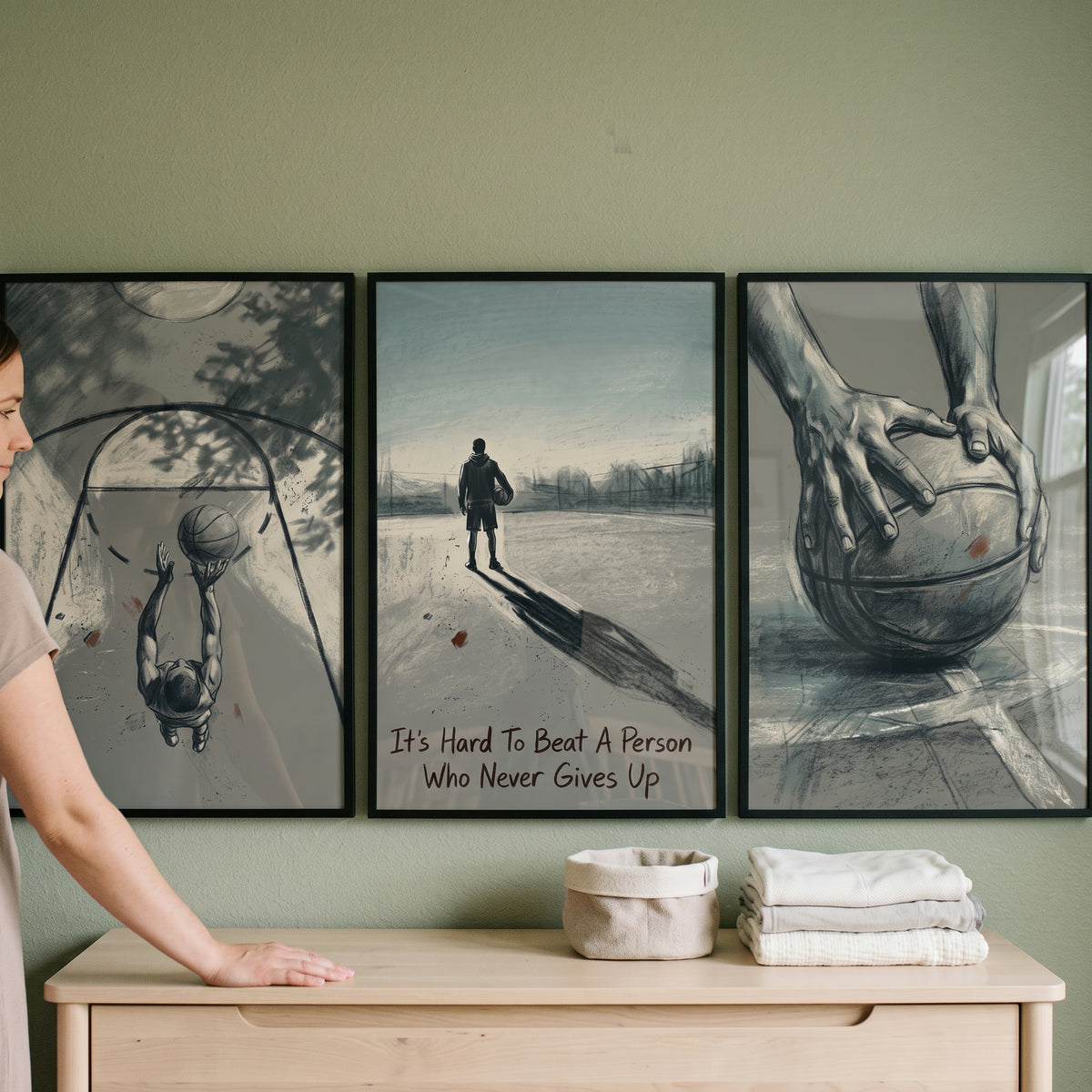 Moody graphite basketball athlete sports wall art set of 3 hanging on a green wall above a dresser with folded towels.