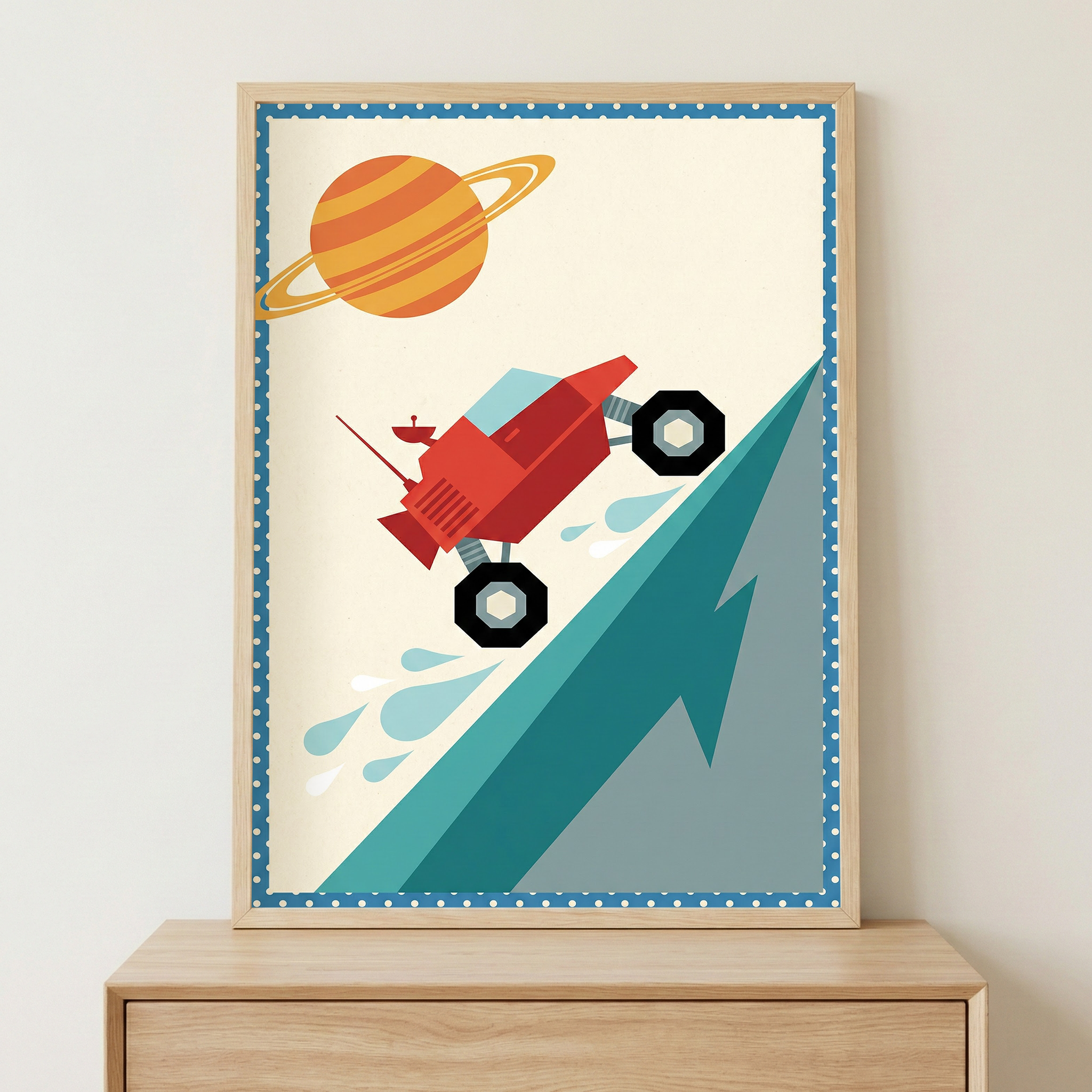 Framed poster of a red cartoon-style rover climbing a steep blue slope with splash marks behind its wheels, set against a cream background with a large orange planet with rings in the sky.