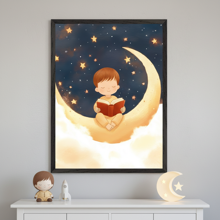 Contemporary room with a white dresser below a large framed print. The art shows a cartoon boy reading a book while sitting on a glowing crescent moon, surrounded by clouds and a starry night sky. A dark vase and a boy doll sit on the dresser.