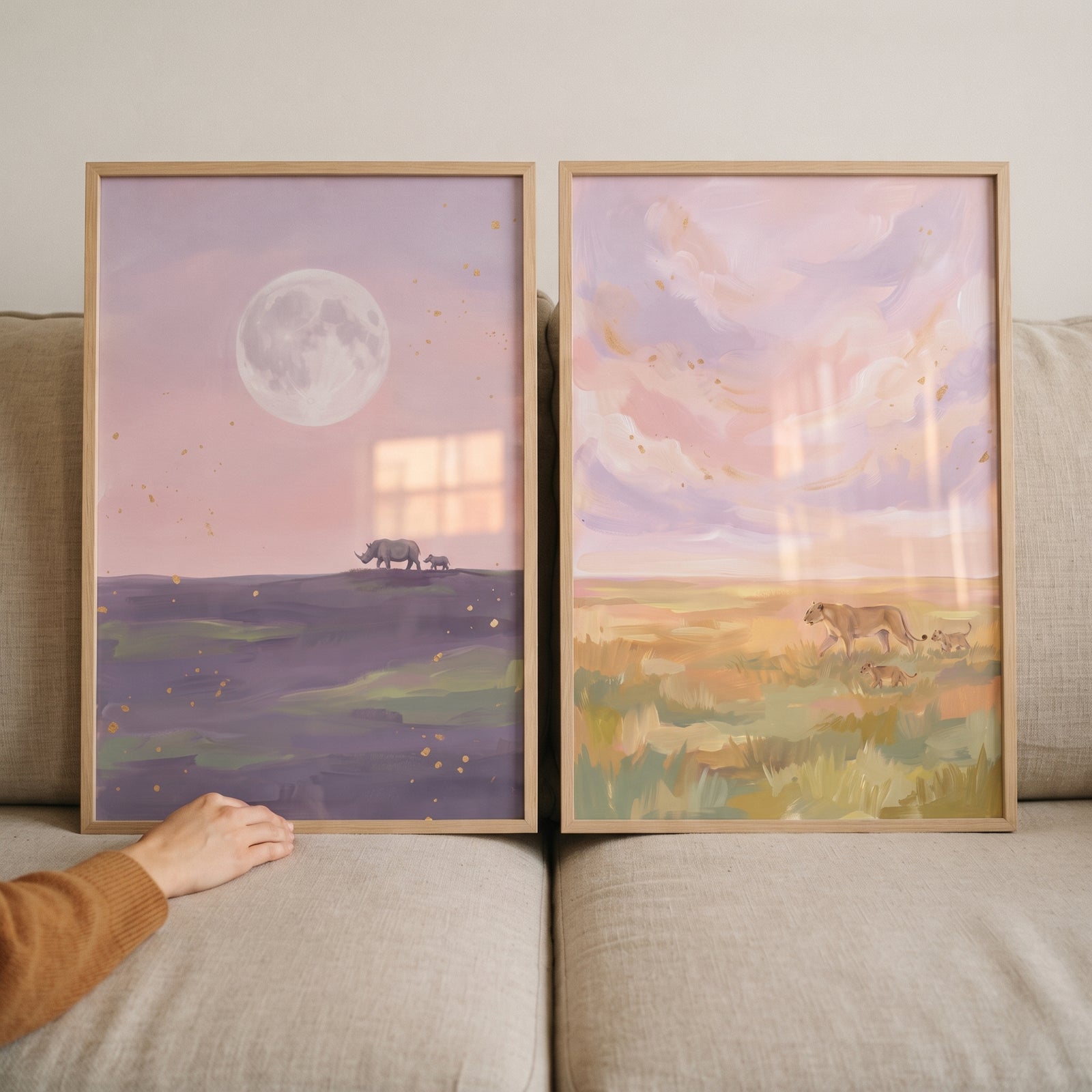 Mother baby safari animals wall art set of 2 with rhinos under a moon and lions in a sunset field.