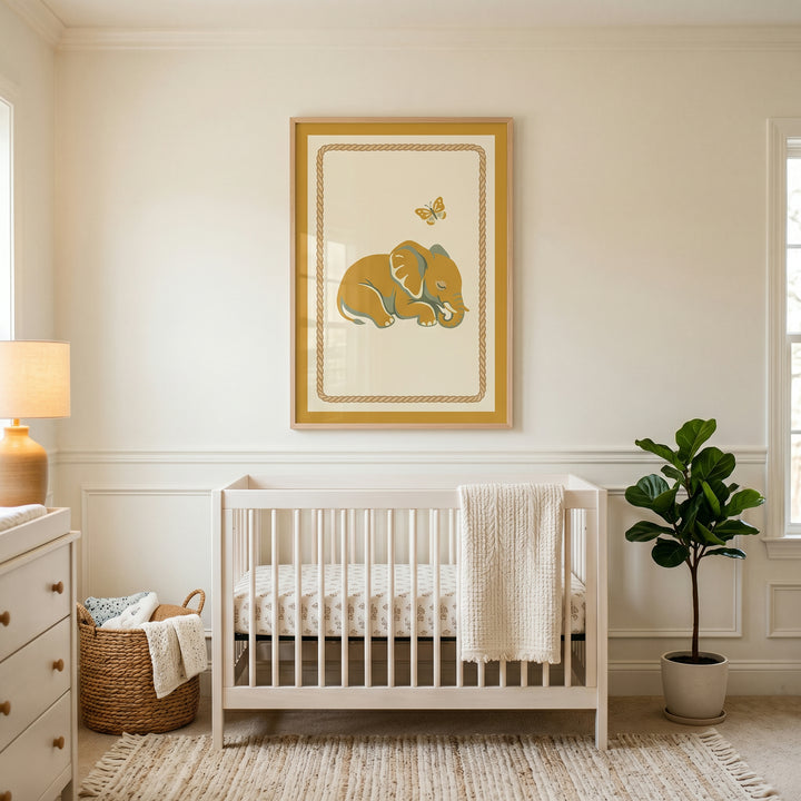 Mustard yellow sleeping elephant wall art hangs above a white crib in a neutral nursery with a potted plant and basket.