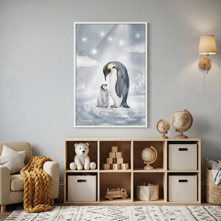 Muted blue nursery penguin wall art above a wooden shelf with toys, a plush bear, and bins next to a cozy chair.