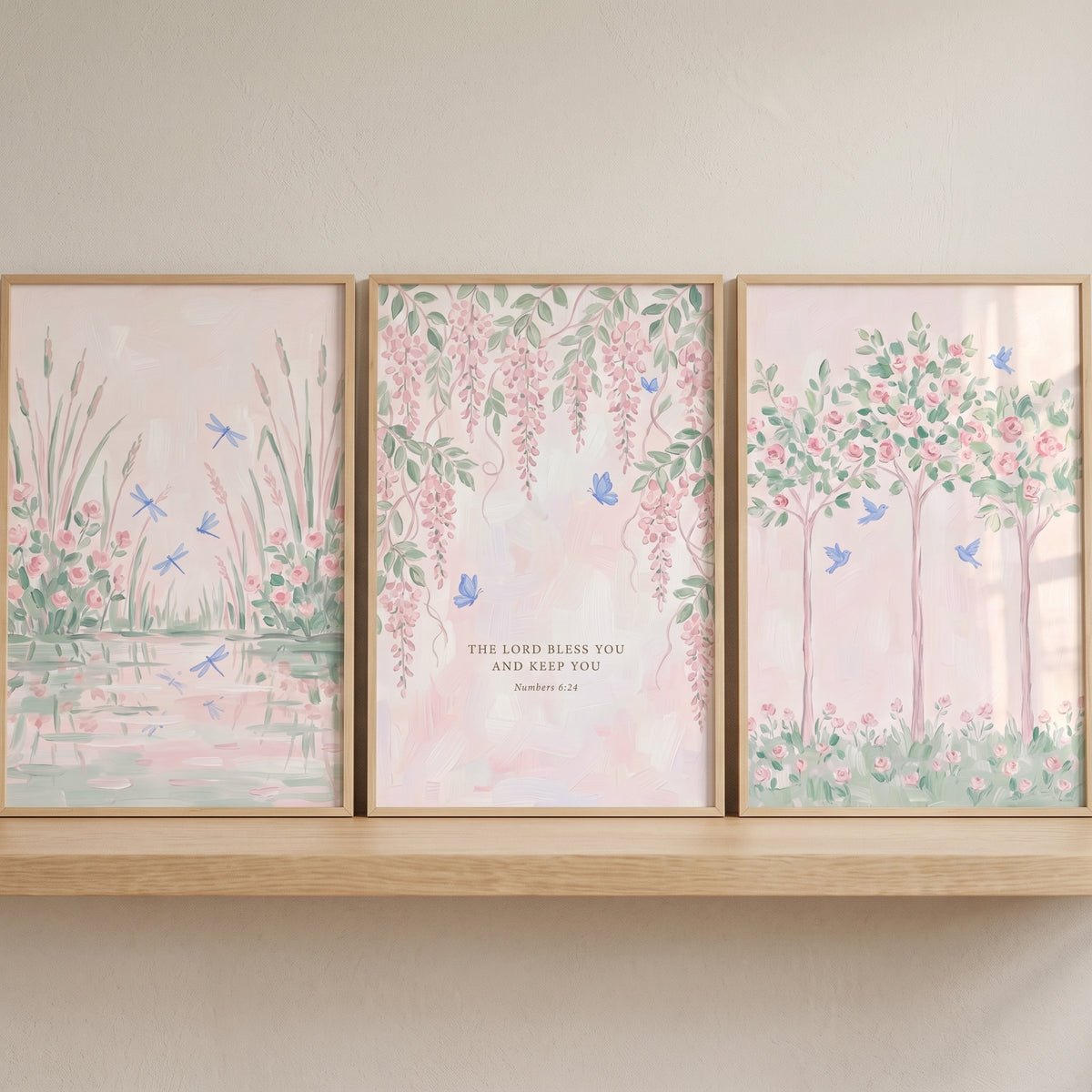 Muted blush botanical garden wall art set of 3 with dragonflies, butterflies, birds, and scripture on a shelf.