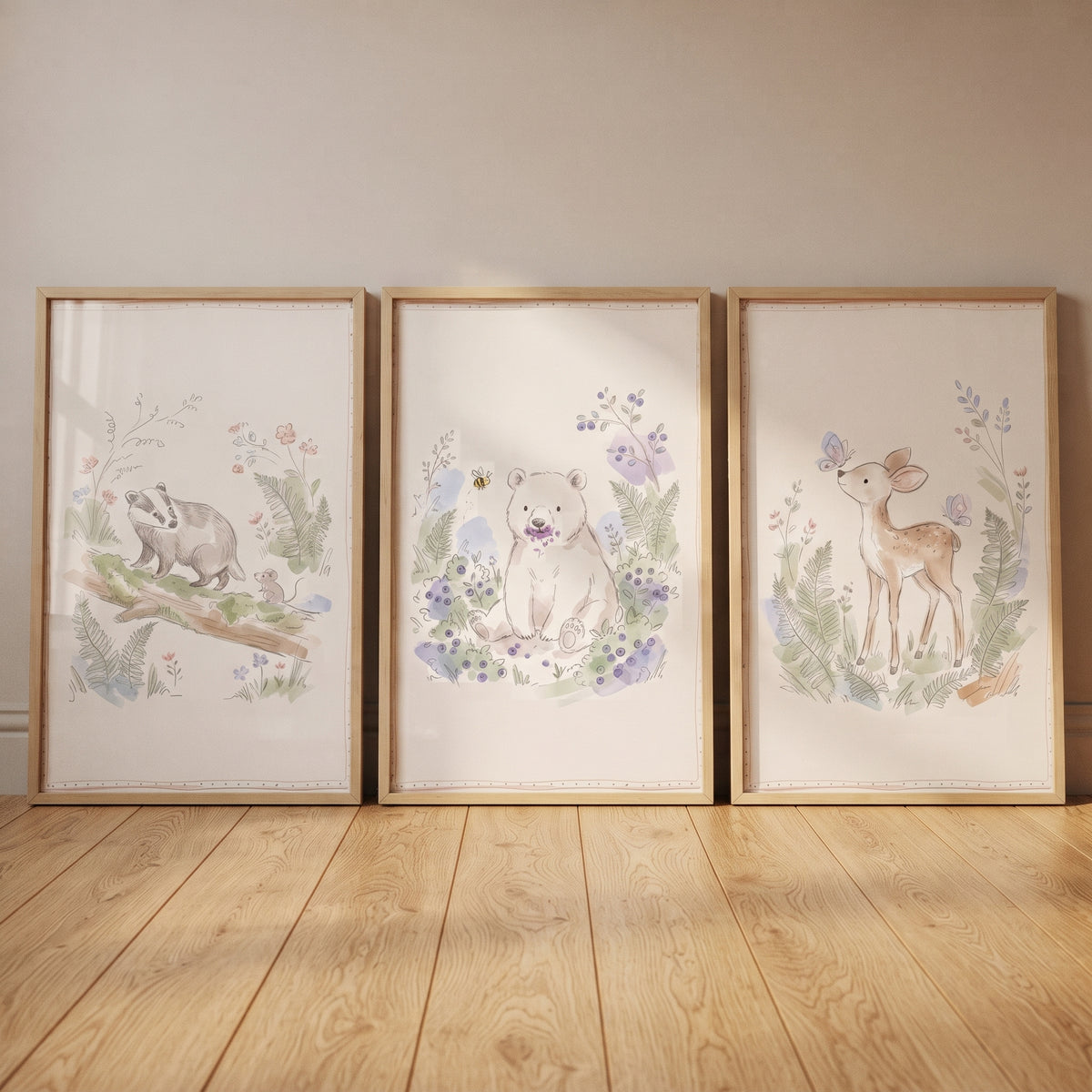Muted botanical woodland creatures artwork set of 3 featuring a badger, bear, and deer in light wood frames on a floor.
