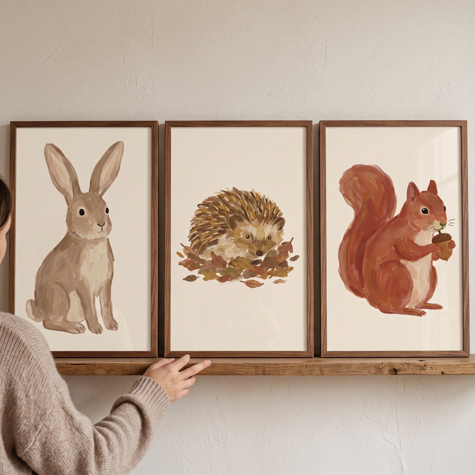 Muted brown forest animals wall art set of 3 featuring a rabbit, hedgehog, and squirrel on a wooden shelf.