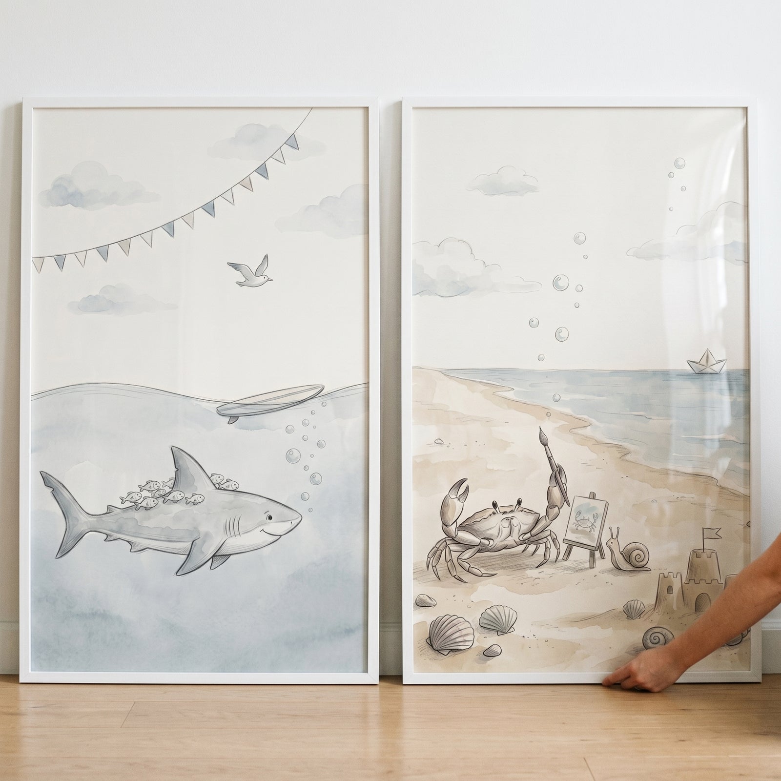 Muted coastal sea animal wall art set of 2 featuring a shark underwater and a crab on a beach with a sandcastle.