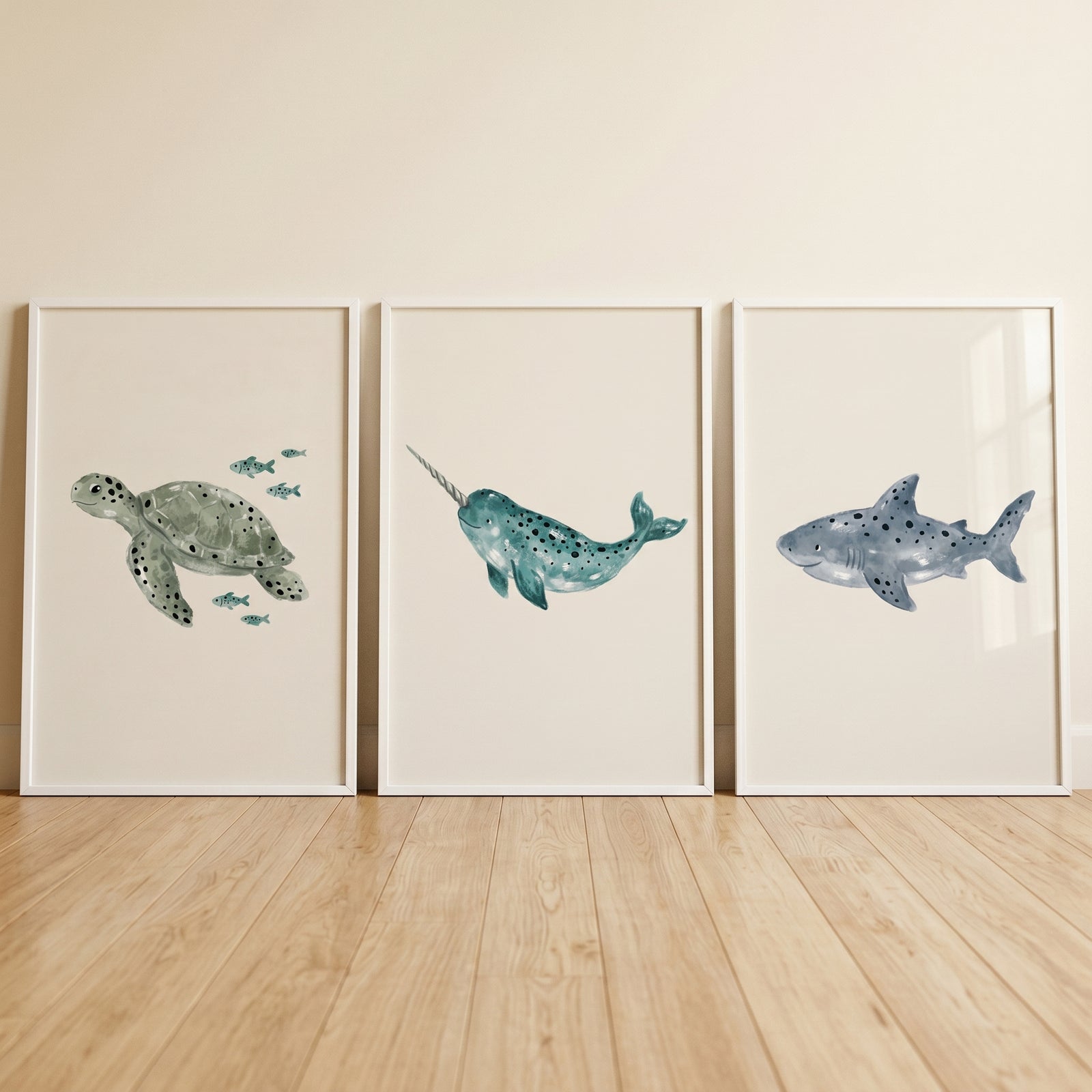 Muted earthy marine life artwork set of 3 featuring a sea turtle, narwhal, and shark in frames on a light wood floor.