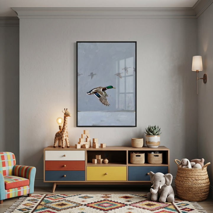 Muted flying mallard duck wall art hangs above a colorful sideboard in a nursery with toys and a giraffe lamp.