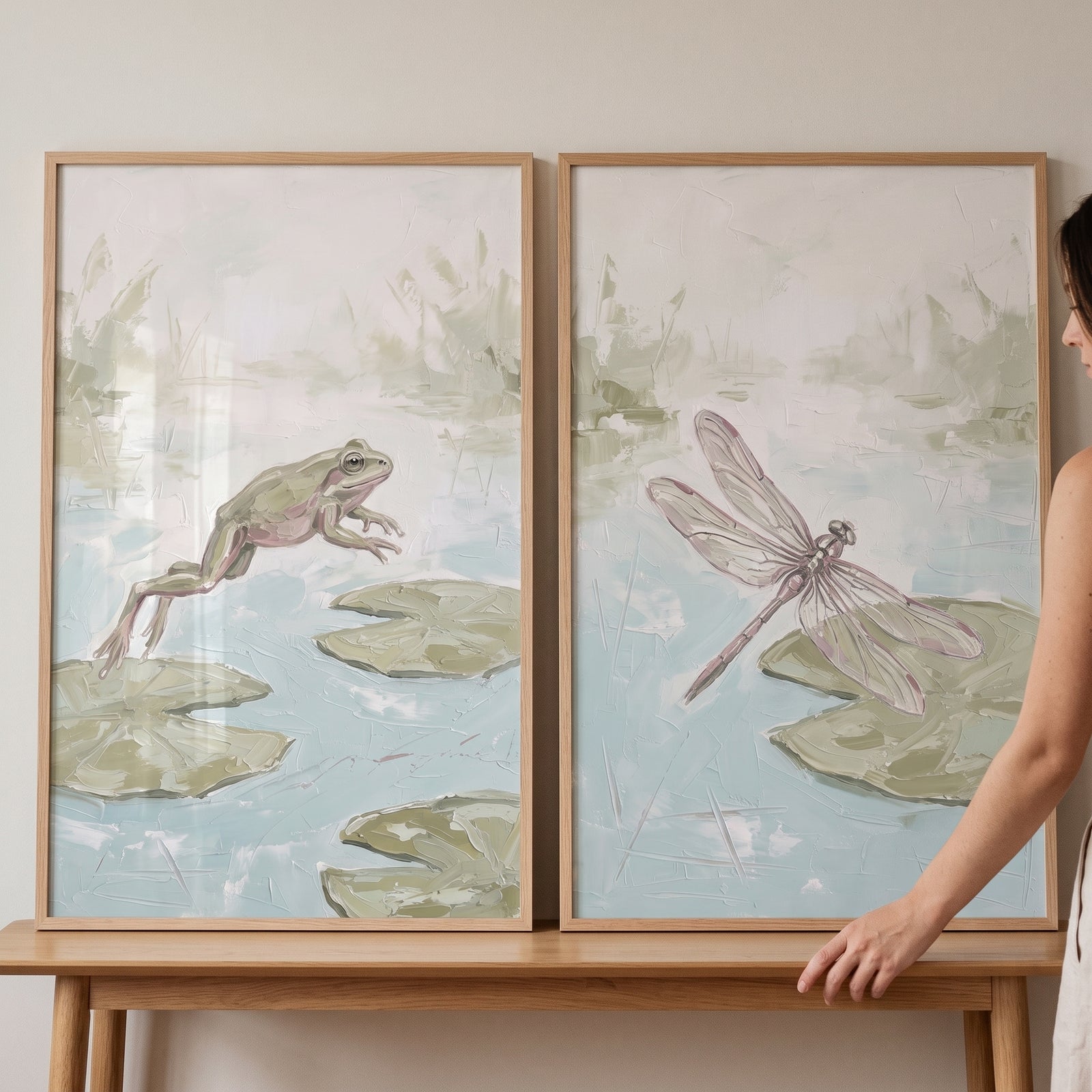 Muted impasto pond animals wall art set of 2 features a jumping frog and a dragonfly over lily pads in soft blue and green.