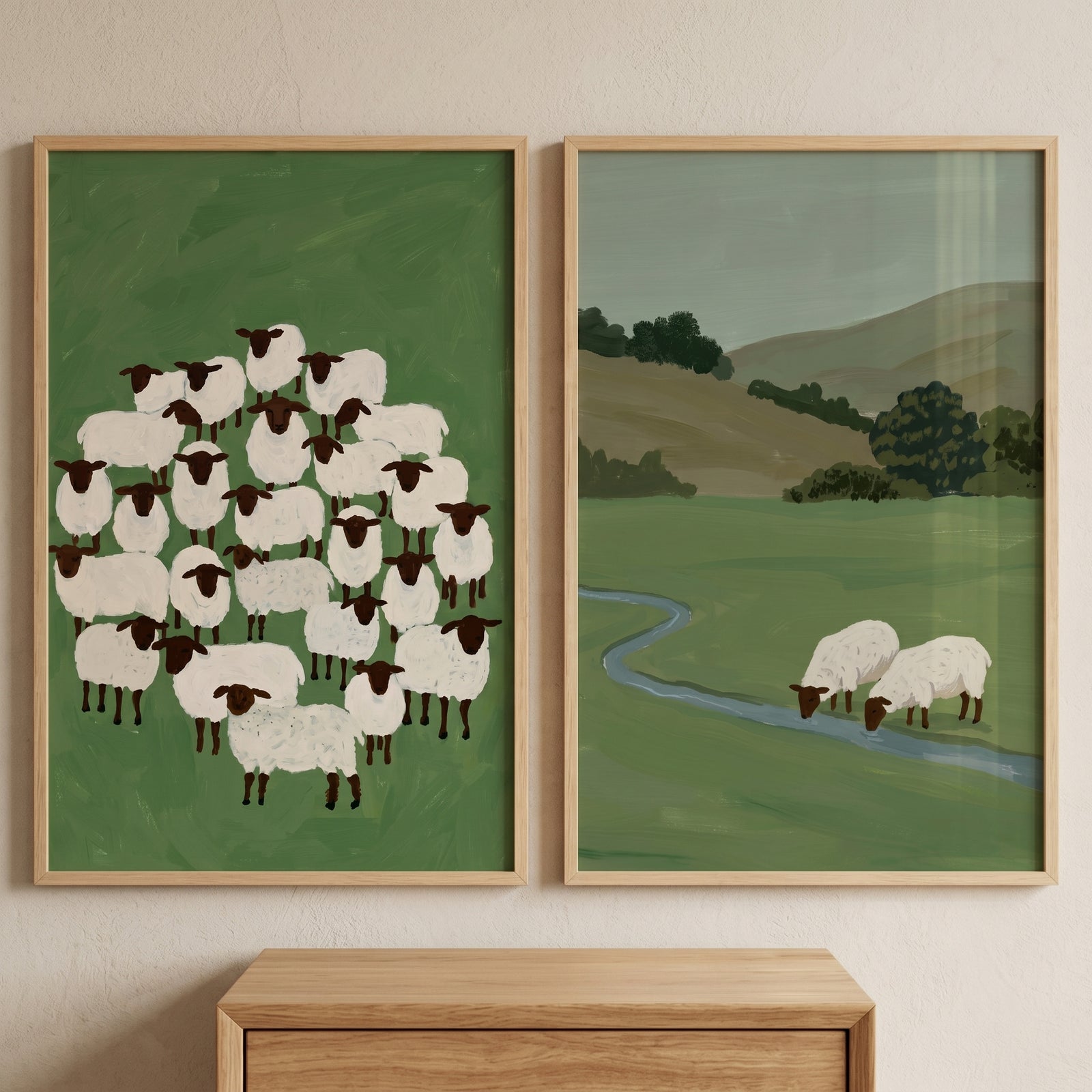 This muted olive pastoral sheep wall art set of 2 shows a cluster of sheep and a landscape with a winding stream.