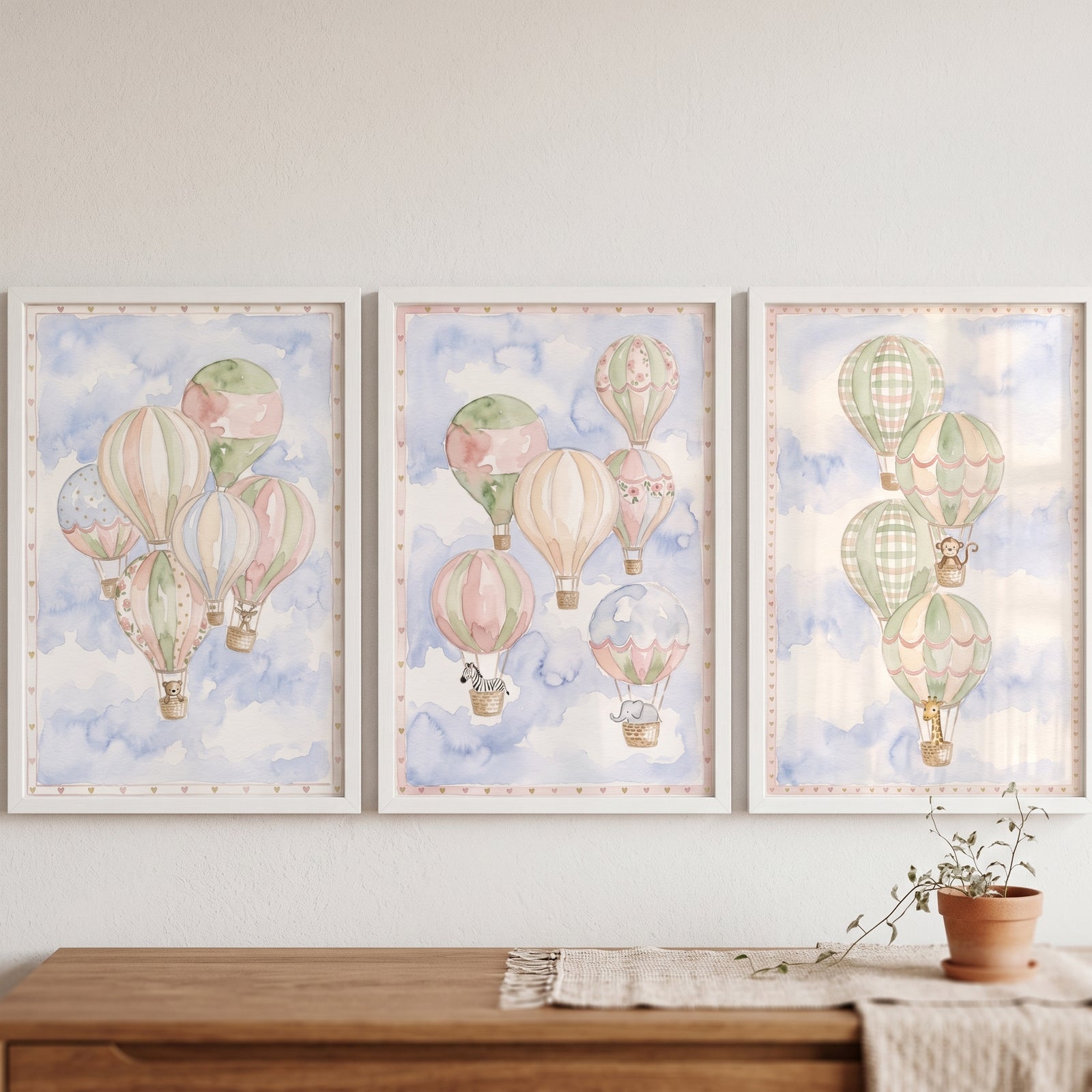Muted palette safari animal artwork set of 3 depicts watercolor hot air balloons and animals in a cloudy blue sky.