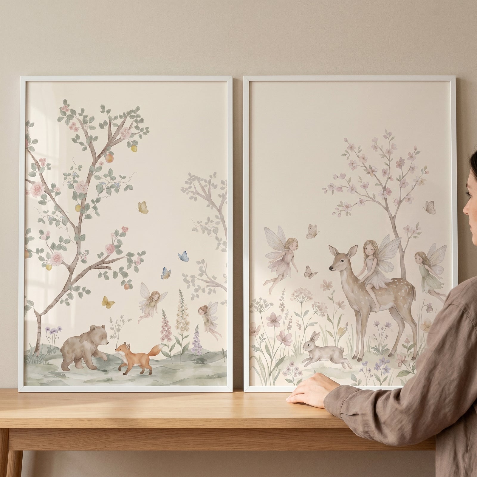 Muted pink blossom fairies wall art set of 2 features watercolor woodland animals and forest fairies in white frames.
