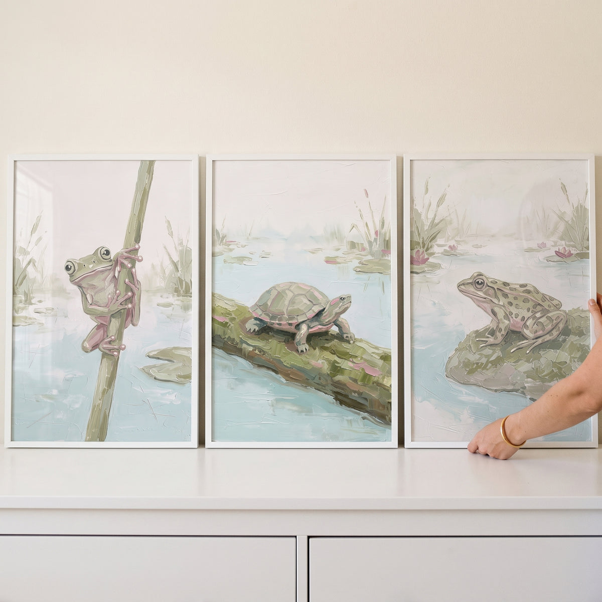 Muted sage aquatic animals wall art set of 3 featuring a frog on a reed, a turtle on a log, and a frog on a rock.