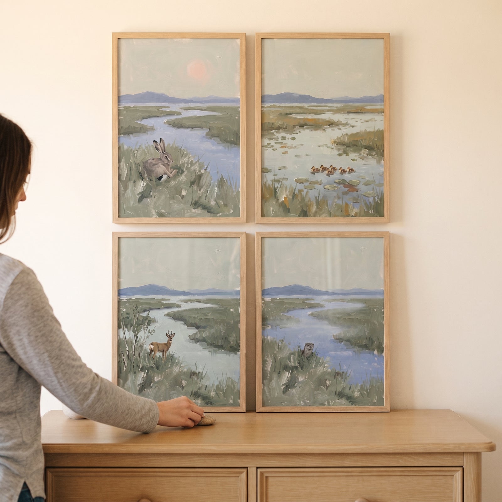 Muted sage marsh wildlife animals wall art set of 4 featuring a hare, ducks, deer, and otter above a dresser.