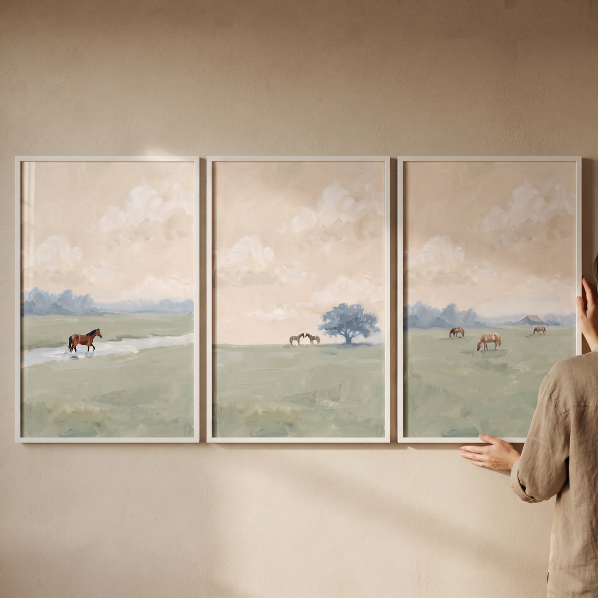 Muted sage meadow horse wall art set of 3 features brown horses in green fields under soft clouds and white frames.