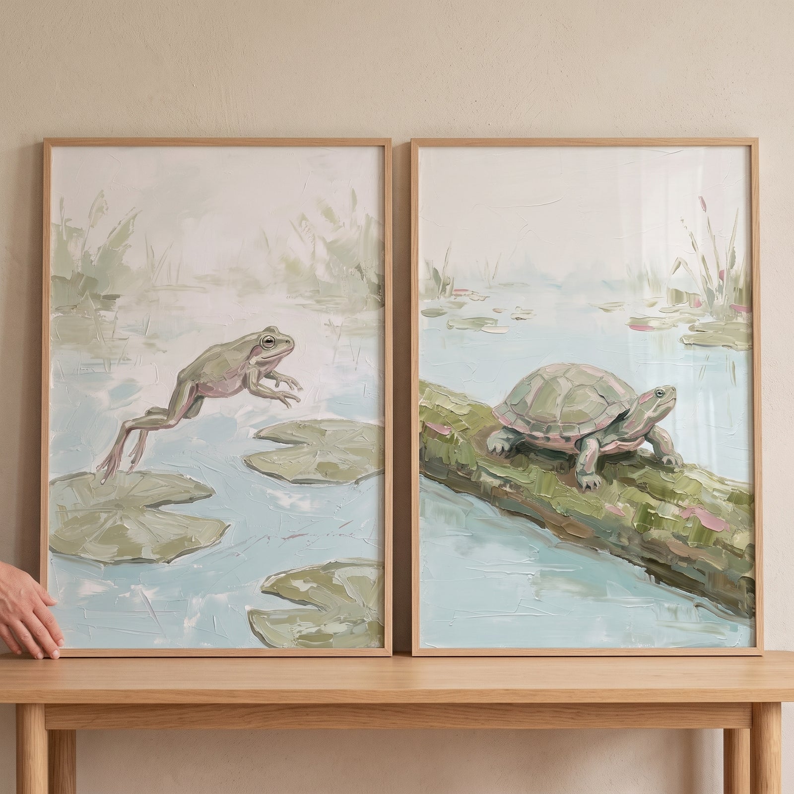 Muted sage wetland animals wall art set of 2 showing a leaping frog and a turtle on a log in soft green and blue tones.
