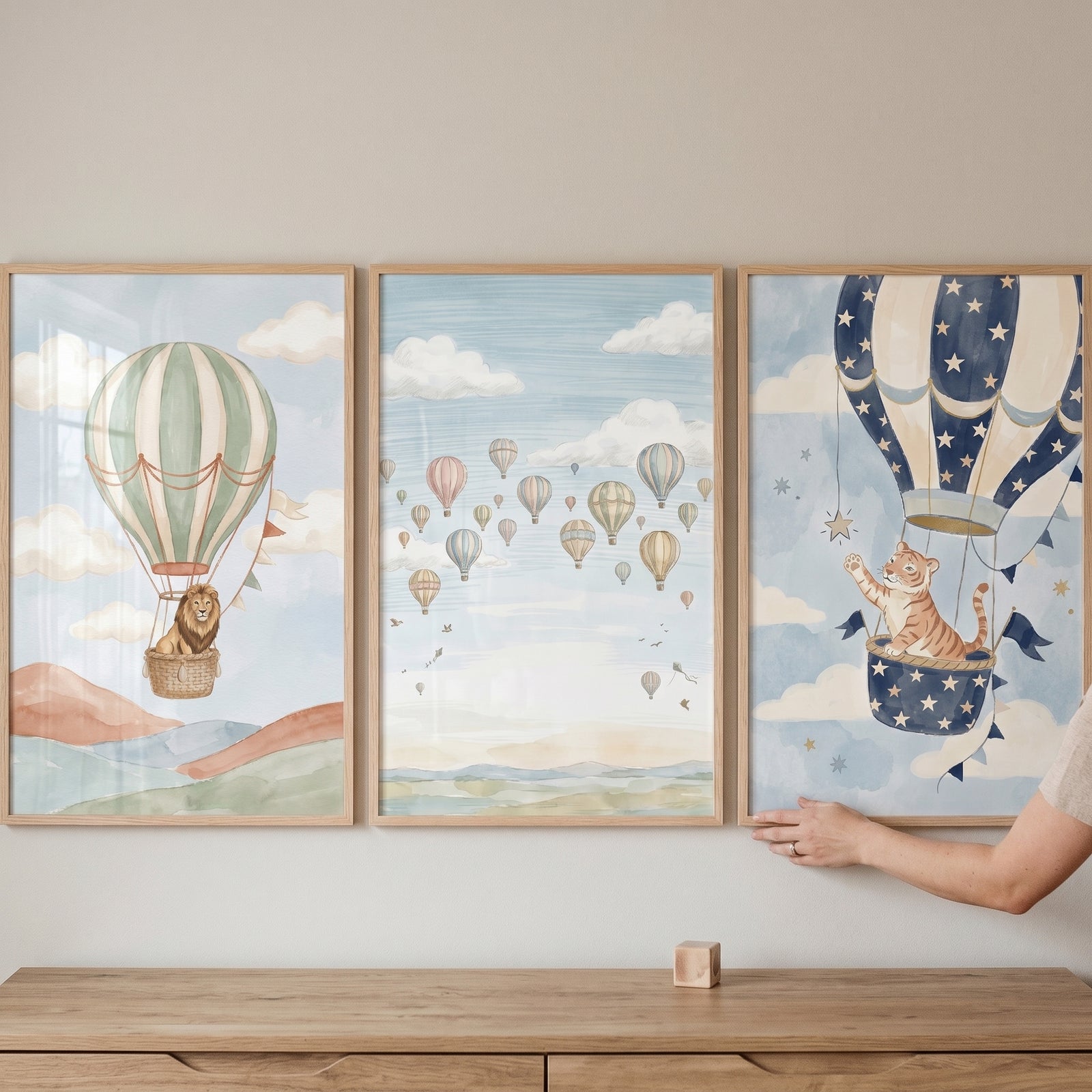 Muted watercolor air balloon wall art set of 3 featuring a lion, a tiger, and several balloons in a soft blue sky.